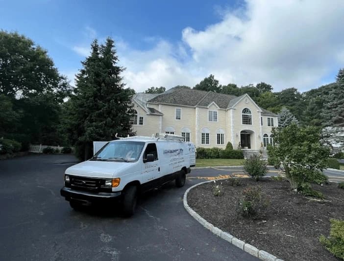 Bedford Power Washing technician performing thorough gutter cleaning service in Bedford