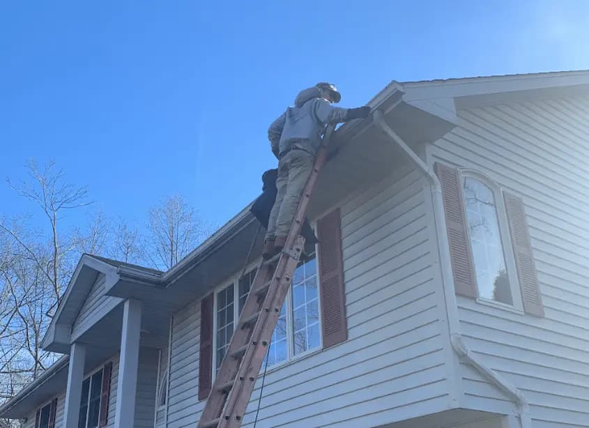 Gutter cleaning and maintenance being performed by Bedford Power Washing in Bedford